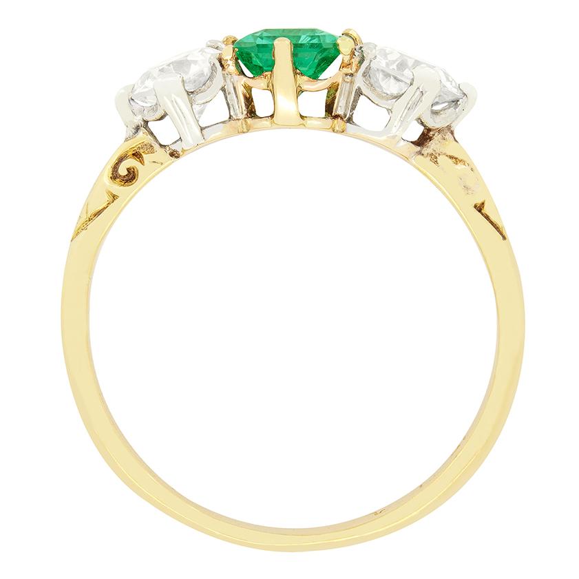 Ein wunderschöner grüner Smaragd wird in diesem viktorianischen Ring von einem Paar Diamanten im Altschliff flankiert. Der zentrale Smaragd ist in einer Kralle gefasst und hat ein Gewicht von 0,40 Karat, die flankierenden Diamanten wiegen jeweils
