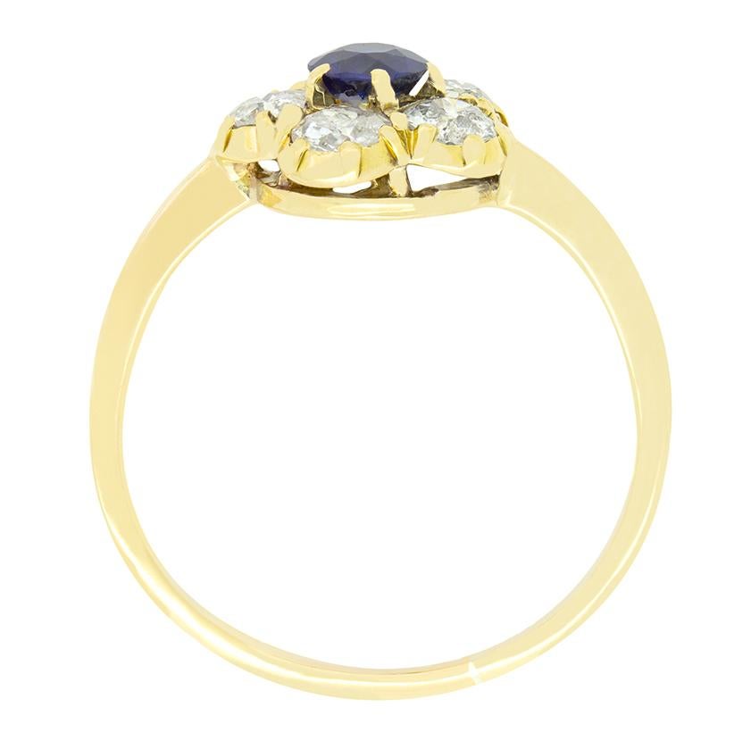 Im Mittelpunkt dieses charmanten viktorianischen Gänseblümchenrings steht ein 0,40 Karat schwerer, tiefblauer Saphir, der fachmännisch in Krallen gefasst ist. Der Saphir ist von fünf Diamanten im Altschliff von insgesamt 1,00 Karat umgeben. Jeder