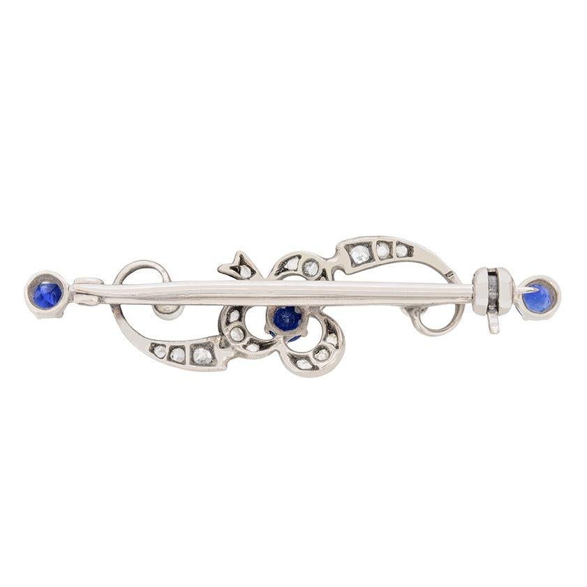 Un grazioso trifoglio è incastonato con splendidi zaffiri blu, diamanti e perle in questa spilla vittoriana. Lo zaffiro principale è di 0,20 carati, mentre gli zaffiri alle due estremità sono di 0,10 carati ciascuno. I diamanti taglio rosa formano