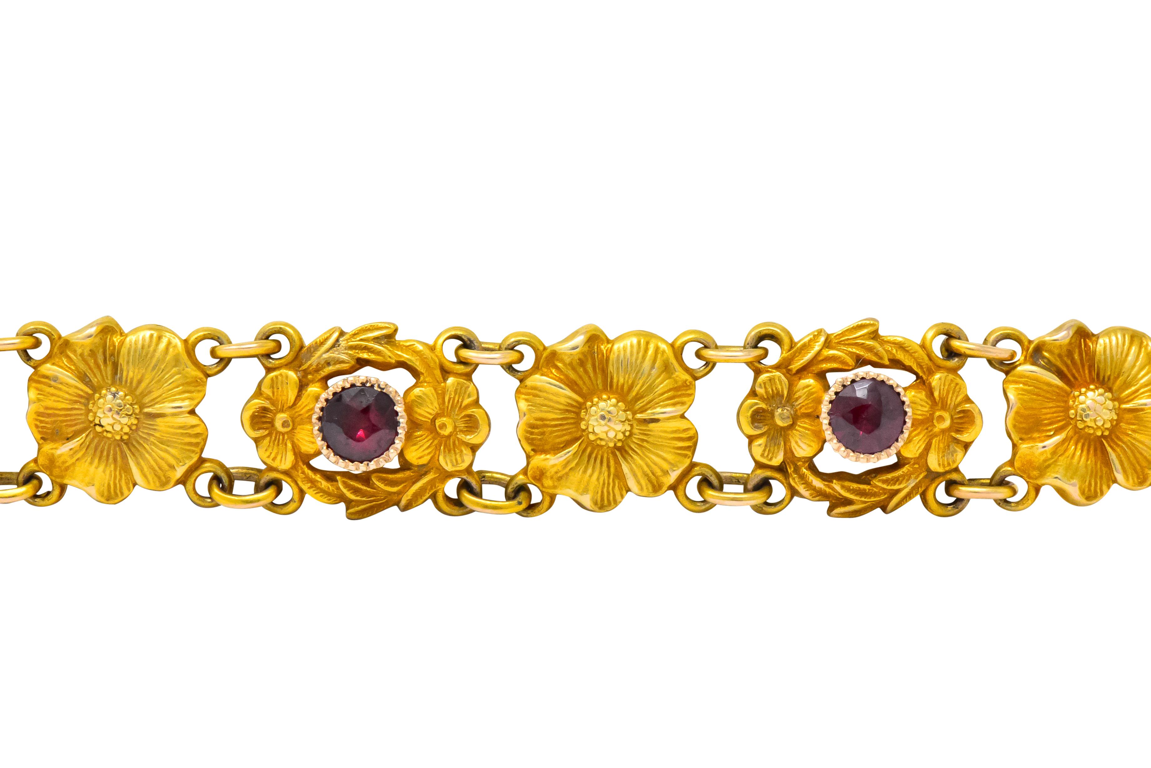 Featuring matte gold flower links alternating with seven millegrain bezels surrounded by two smaller flowers, connected throughout by jump ring spacer links

Set with seven round cut rubies weighing approximately 0.45 carat total, medium-dark