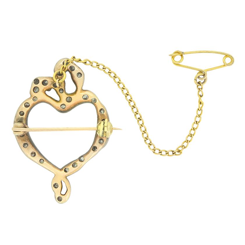 Risalente all'epoca vittoriana, questa incantevole spilla con fiocco a cuore è stata sapientemente realizzata a mano in argento e oro rosa a 15 carati. Un totale di 0,50 carati di diamanti taglio vecchio adornano la forma a cuore creando un