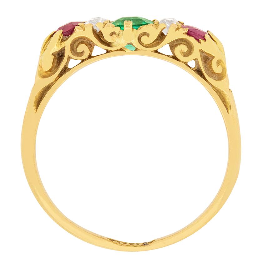 A gorgeous green emerald is set in the centre of this unique Victorian ring. The vibrant emerald is emerald cut, and is 0.50 carat. A 0.20 carat ruby is set on each end of the ring, and are separated from the emerald by four old cut diamonds. They