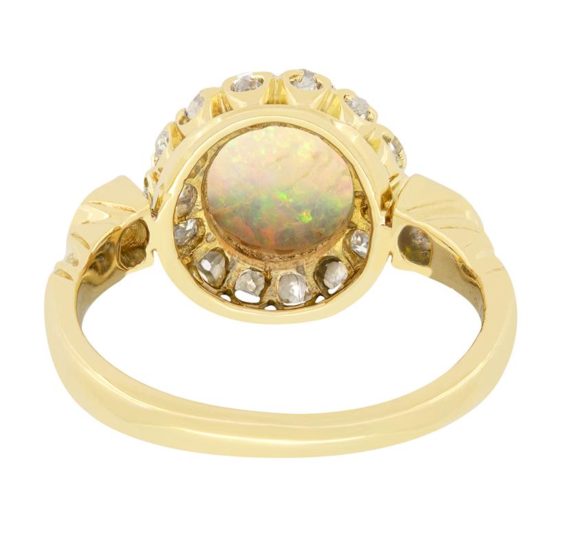 An enchanting opal takes centre stage in this stunning Victorian cluster. The 0.50 carat opal is sit within 18 carat yellow gold claws and is surrounded by a halo of fourteen old cut diamonds, with an additional stone set on each shoulder. The