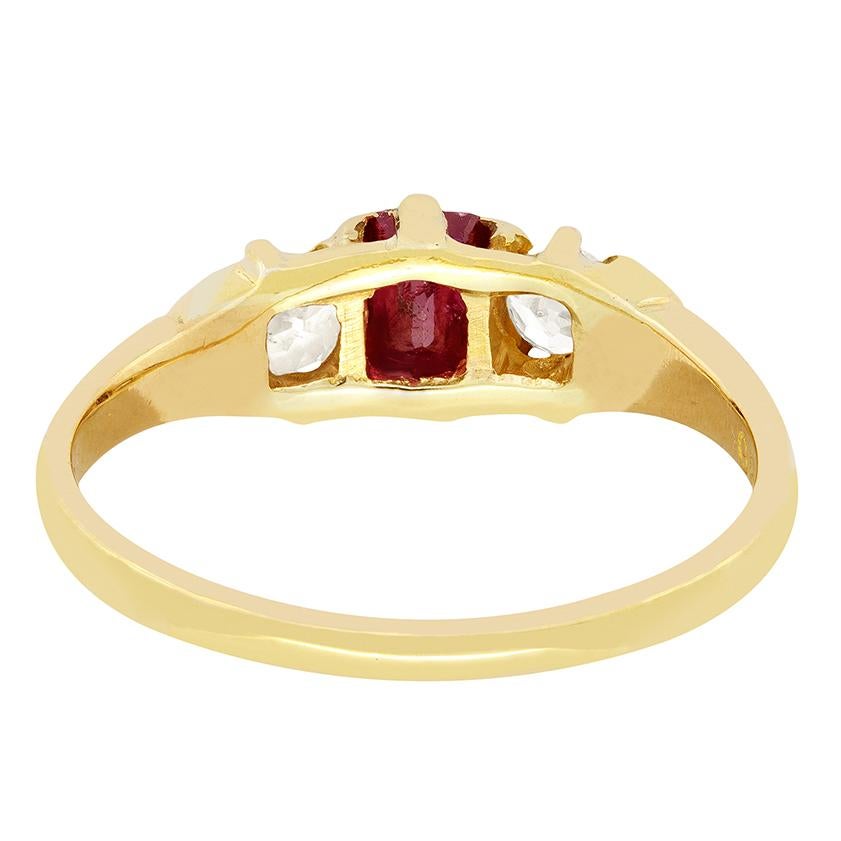 A wonderful natural ruby is flanked by a pair of old cut diamonds in this classic Victorian trilogy ring. The beautifully vibrant ruby is a 0.50 carat emerald cut stone. Each diamond is 0.20 carat and match in quality with a colour of I and clarity