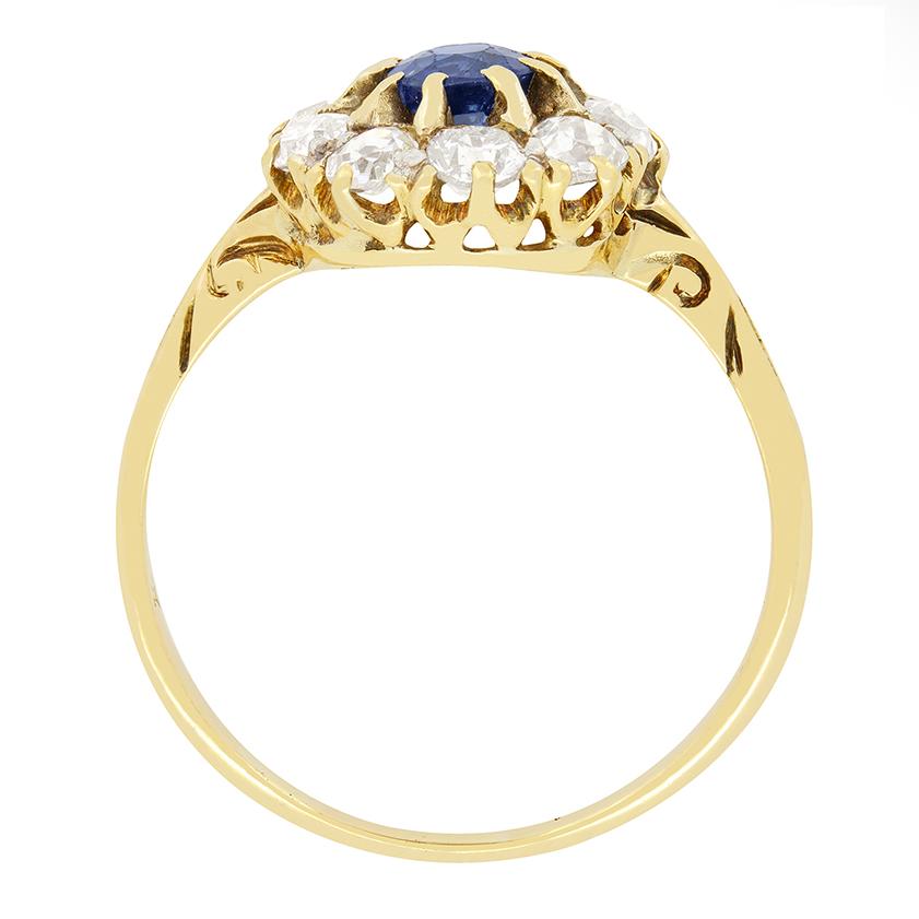 A glistening example of Victorian fine craftsmanship this halo ring features a central sapphire surrounded by nine old cut diamonds. The beautiful central sapphire is a 0.50 carat old cut gem, firmly claw set in the 18 carat yellow gold mount. Each