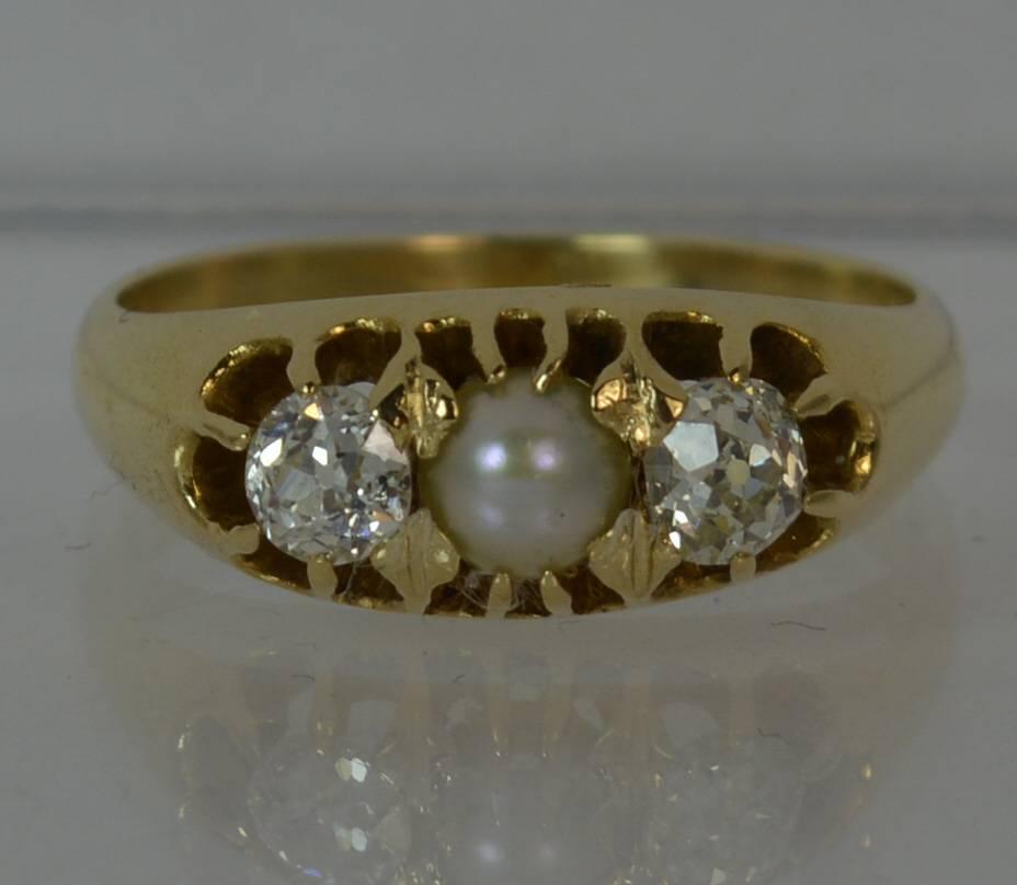 An mid Victorian period trilogy ring. Solid 15 carat yellow gold example. c1880.

​Designed with a natural pearl to the centre, 4.3mm diameter. Each side has a natural old cut diamond in claw setting, each diamond is approx 0.30 carats.Very clean,