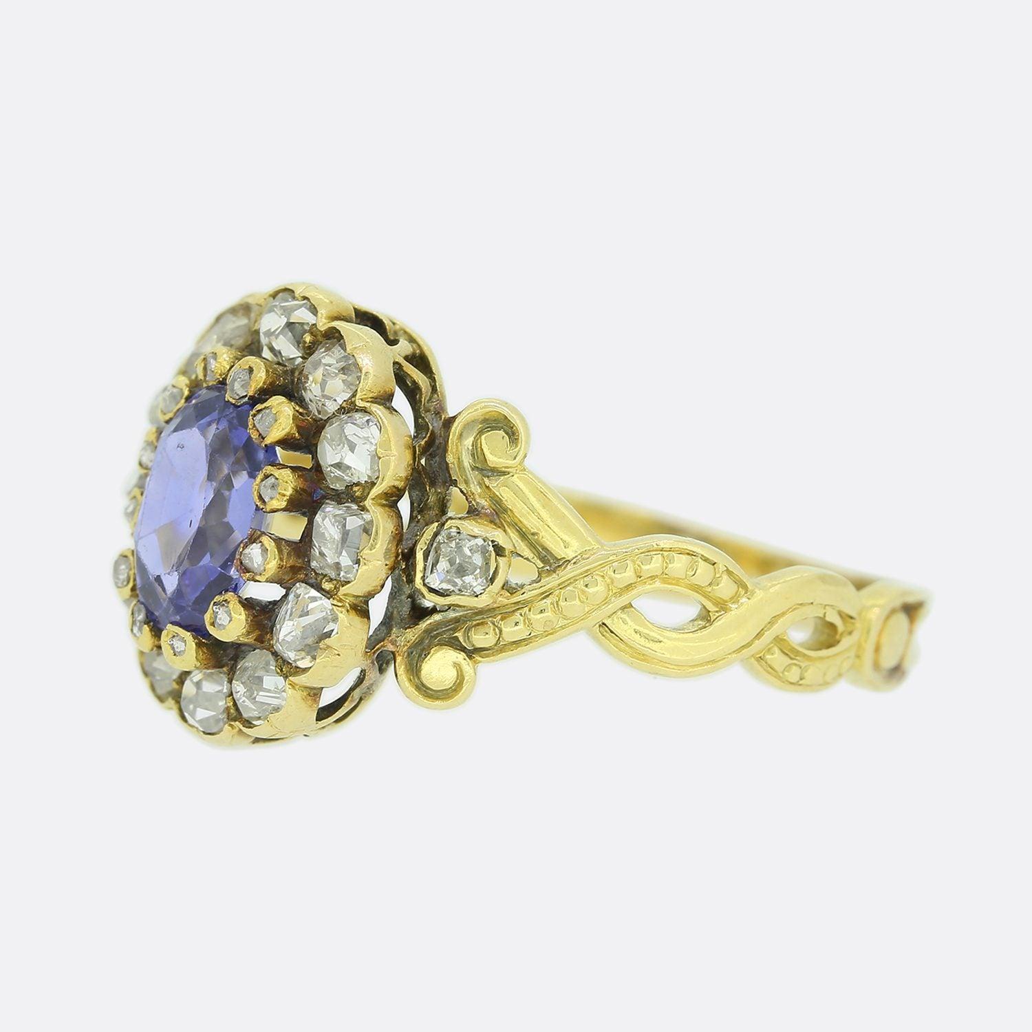 Dies ist ein 15ct Gelbgold Saphir und Diamant-Cluster-Ring aus der viktorianischen Ära. Der zentrale Saphir hat eine ovale Form und sitzt inmitten einer diamantenen Krallenfassung, die wiederum von einer Reihe von Diamanten im Tafelschliff umrahmt