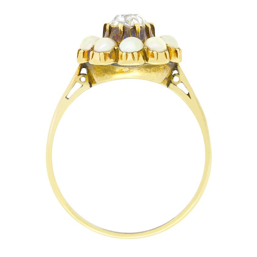 Aus den 1880er Jahren stammt dieser wunderschöne viktorianische Ring mit einem zentralen Diamanten, der von Perlen umgeben ist. Der zentrale Diamant ist ein alter Stein im Ovalschliff mit einem Gewicht von 0,60 Karat. Der Stein hat eine Farbe von G