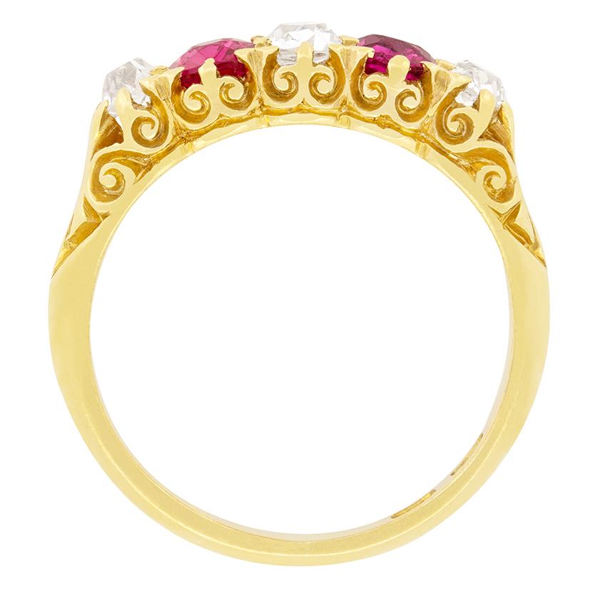 This Victorian five stone ring features a stunning combination of old cut diamonds and pink sapphires set in intricately carved 18 carat yellow gold. The central diamond weighs 0.30 carat with smaller diamonds on either end weighing 0.20 carat a