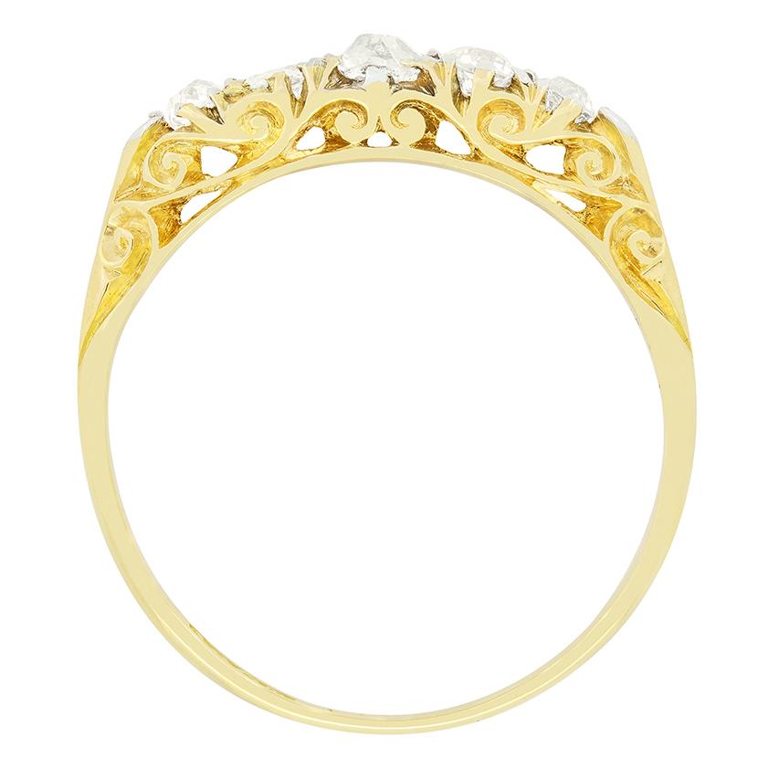 Cette bague victorienne classique à tige sculptée est ornée de cinq diamants de taille ancienne progressant en taille. Au centre se trouve la plus grosse pierre pesant 0,20 carat, flanquée de deux pierres de 0,15 carat et terminée par deux pierres