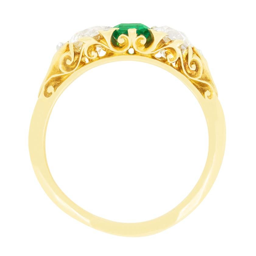 This truly stunning carved shank trilogy ring dates back to the Victorian era. Taking centre stage, a vibrant green emerald is flanked by two old cut diamonds with a further rose cut diamonds set in between, giving that extra sparkle. The central