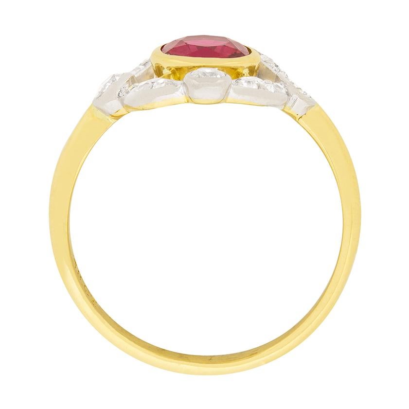 This whimsical Victorian ring centres a 0.70 carat ruby surrounded by old cut diamonds. The ruby is old cut, and is a gorgeous red colour. To each side of the ruby lies a 0.05 carat old cut diamond, which are connected by a total of 0.16 carat of