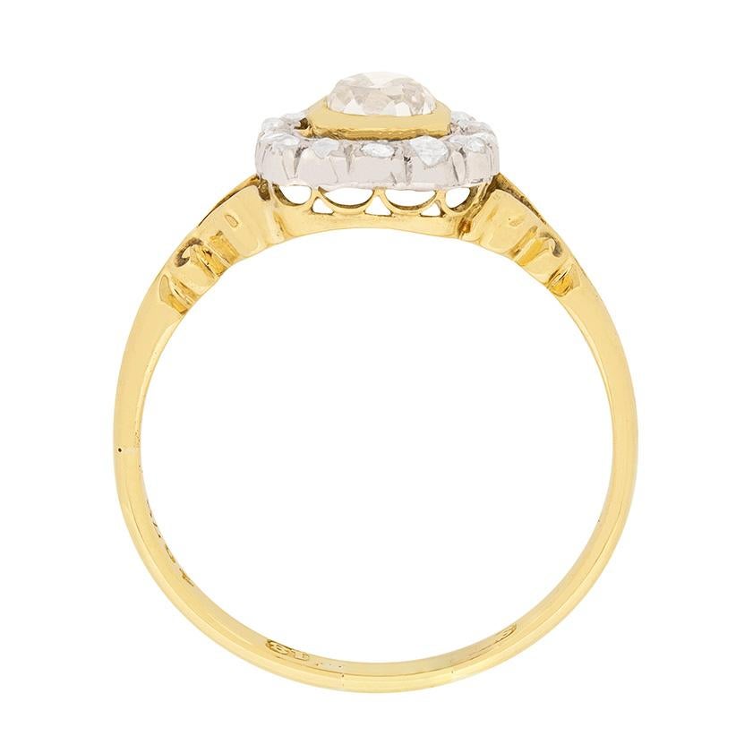 This unique Victorian era diamond ring truly is a rarity. Dating back to the 1880s, the ring is hand made from 18 carat yellow gold. The champagne coloured central diamond is a 0.74 carat old cushion cut which is rub over set. The clarity of the