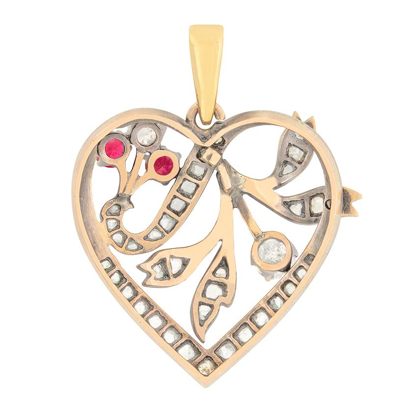 This sweet heart pendant was created in the 1880s. It is embellished with lovely diamond and ruby set flowers. The principle old cut diamond is 0.25 carat, while the bouquet of flowers to the right features two 0.20 carat old cut rubies with a 0.20