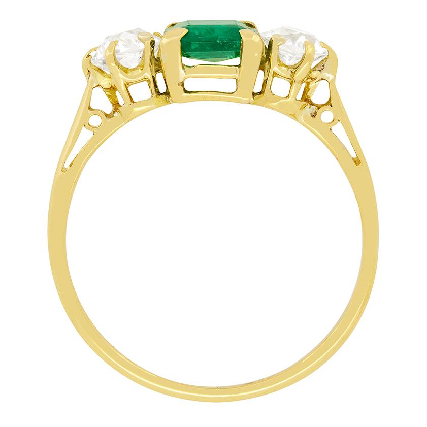 Ein temperamentvoller Smaragd mit einem Gewicht von 0,75 Karat sitzt zwischen zwei glitzernden Diamanten im Altschliff. Die Diamanten haben ein Gewicht von je 0,40 Karat und werden als H in der Farbe und VS in der Reinheit geschätzt. Der aus der