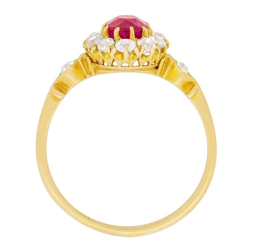 This stunning Victorian ring features an old cushion cut pink sapphire surrounded by a halo of diamonds. The pink sapphire is a wonderful, vibrant colour, and is 0.80 carat. It is surrounded by a halo of 12 old cut diamonds, totalling to 0.60 carat.