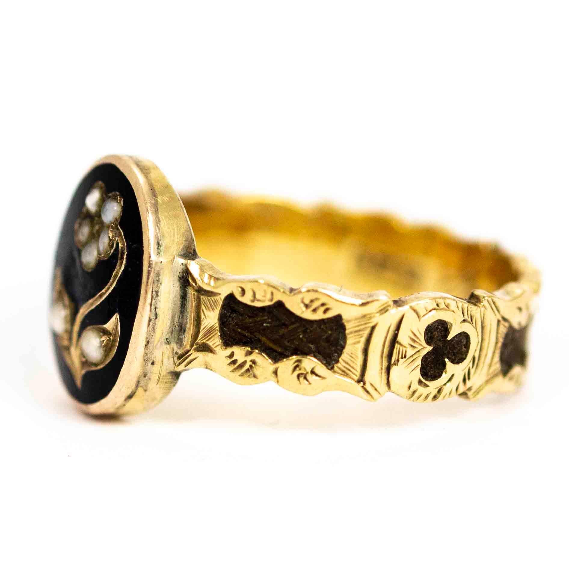 A stunning antique Victorian mourning ring. Fronted with a beautiful forget me not flower motif set with pearls on an oval of black enamel. The band has a beautiful ornate design throughout and is set with woven hair. The inscription on the inside