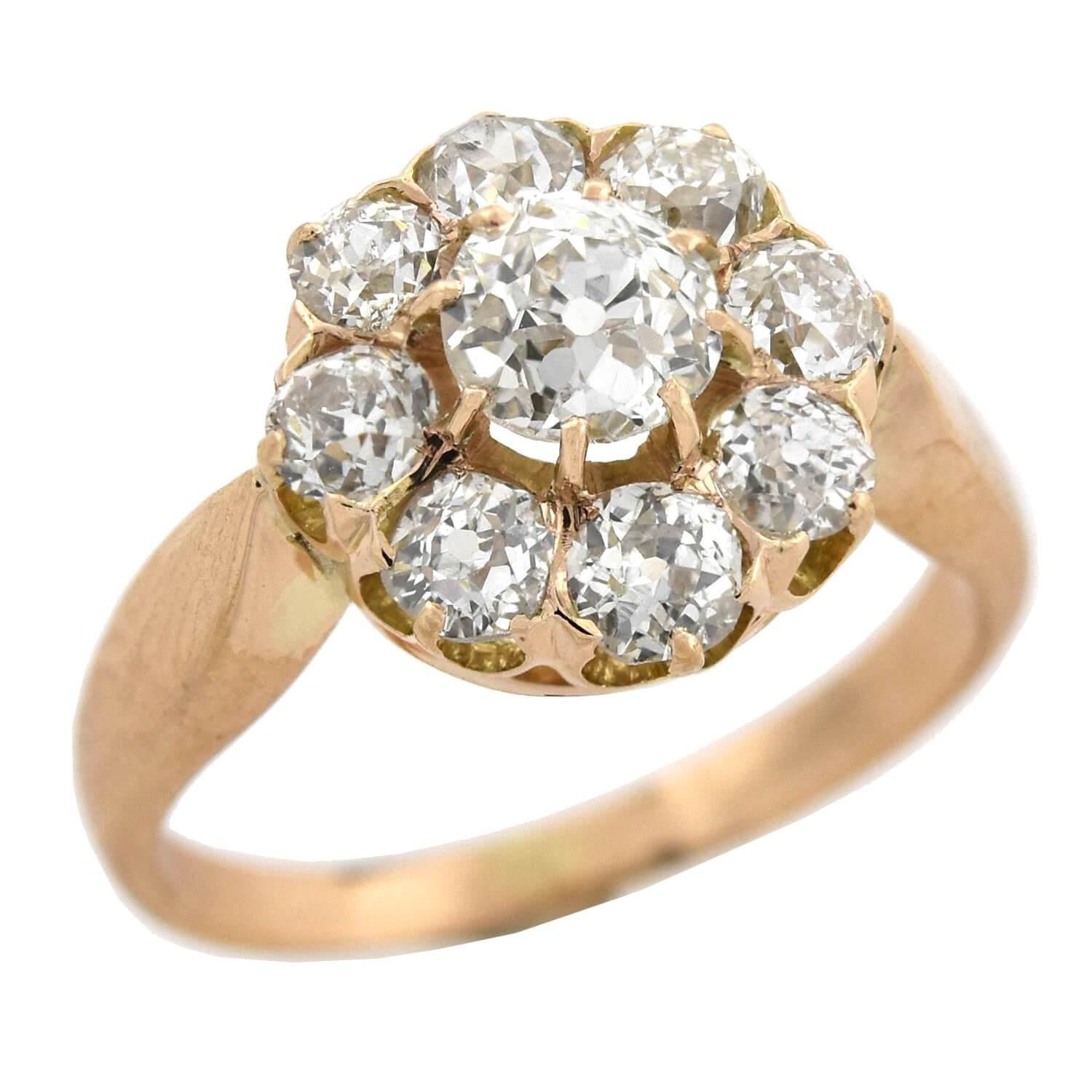 An exquisite diamond cluster ring from the Victorian (ca1880) era! This gorgeous piece is crafted in 18kt rose gold and adorns an approximately 0.45ct old Mine Cut diamond at the center of a sparkling border. The stone rests slightly above the 8