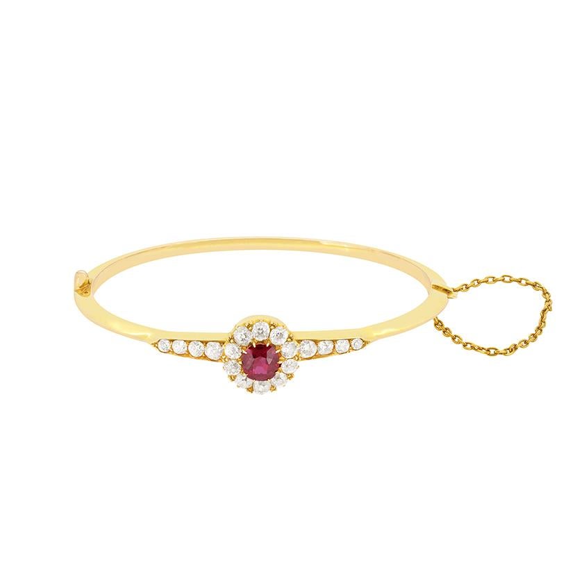 The beautiful Victorian bangle features a vibrant 1.00 carat ruby at its centre surrounded by a cluster of old cut diamonds. The ruby is an old cut stone and is completely natural and unheated. The surrounding diamonds, which continue down the