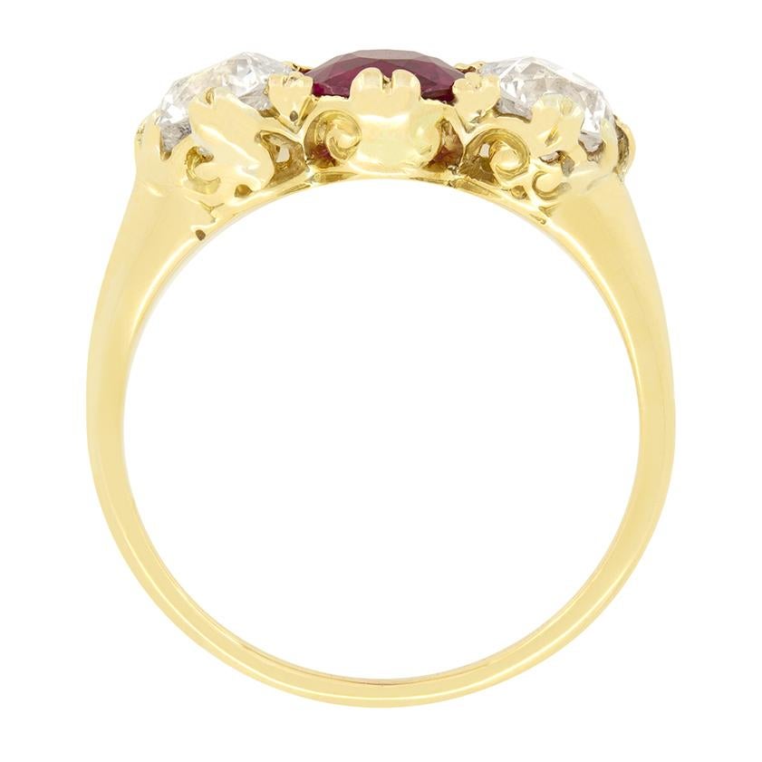 Dating back to the 1880s, this stunning trilogy ring features a central ruby flanked by old cut diamonds. The Vivid red ruby is an old cut stone weighing 1.00 carat and Burmese in origin. The accompanying diamonds match at 0.70 carat and are of good