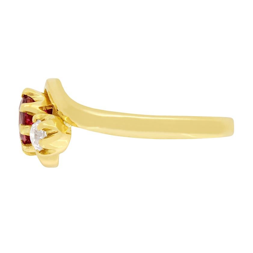An old oval cut ruby is the centre of this lovely Victorian twist ring. The ruby is a deep red colour, and is 1.00 carat. An old cut diamond is set diagonally on either side of the gemstone, adding a sweeping sense of movement, along with the curved