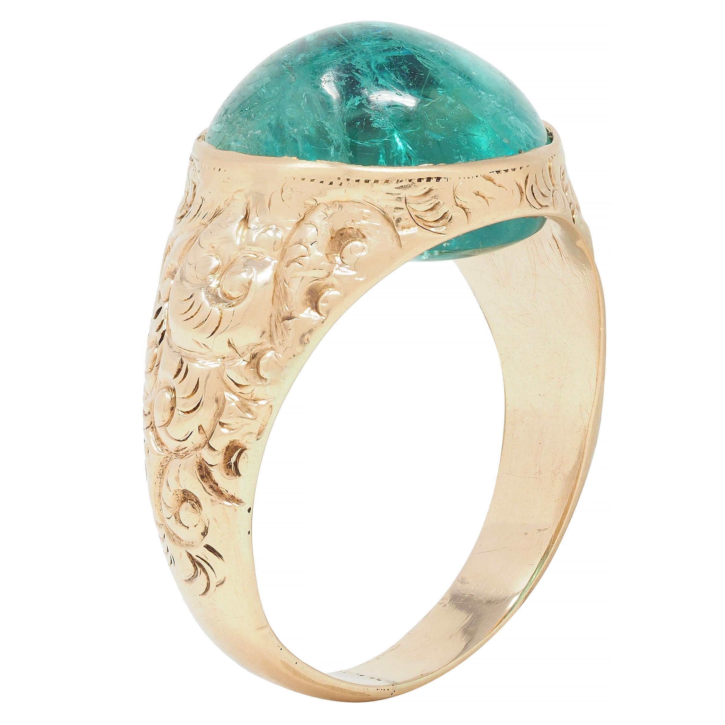 Centering an oval-shaped emerald domed double cabochon weighing approximately 10.16 carats 
Translucent medium bluish-green in color with natural inclusions 
Bezel set with a grooved scroll motif surround
Tested as 14 karat gold 
Circa: 1880s
Ring