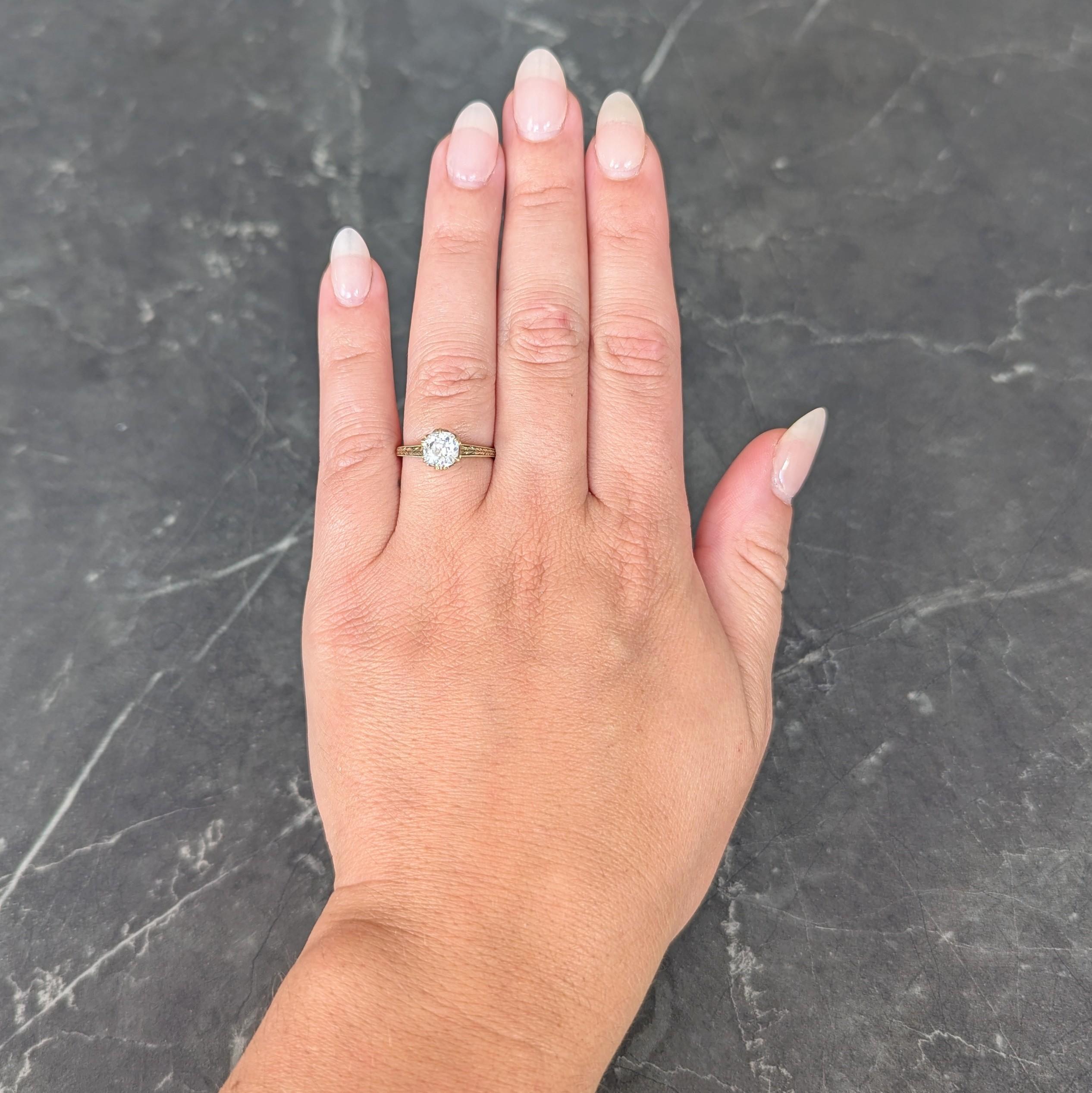 Centering an old mine cut diamond weighing 1.05 carats total - I color with SI1 clarity
Prong set in a pierced basket with milgrain detailing
Flanked by engraved wheat motif shoulders
With an engraved scroll motif profile 
Stamped for 14 karat