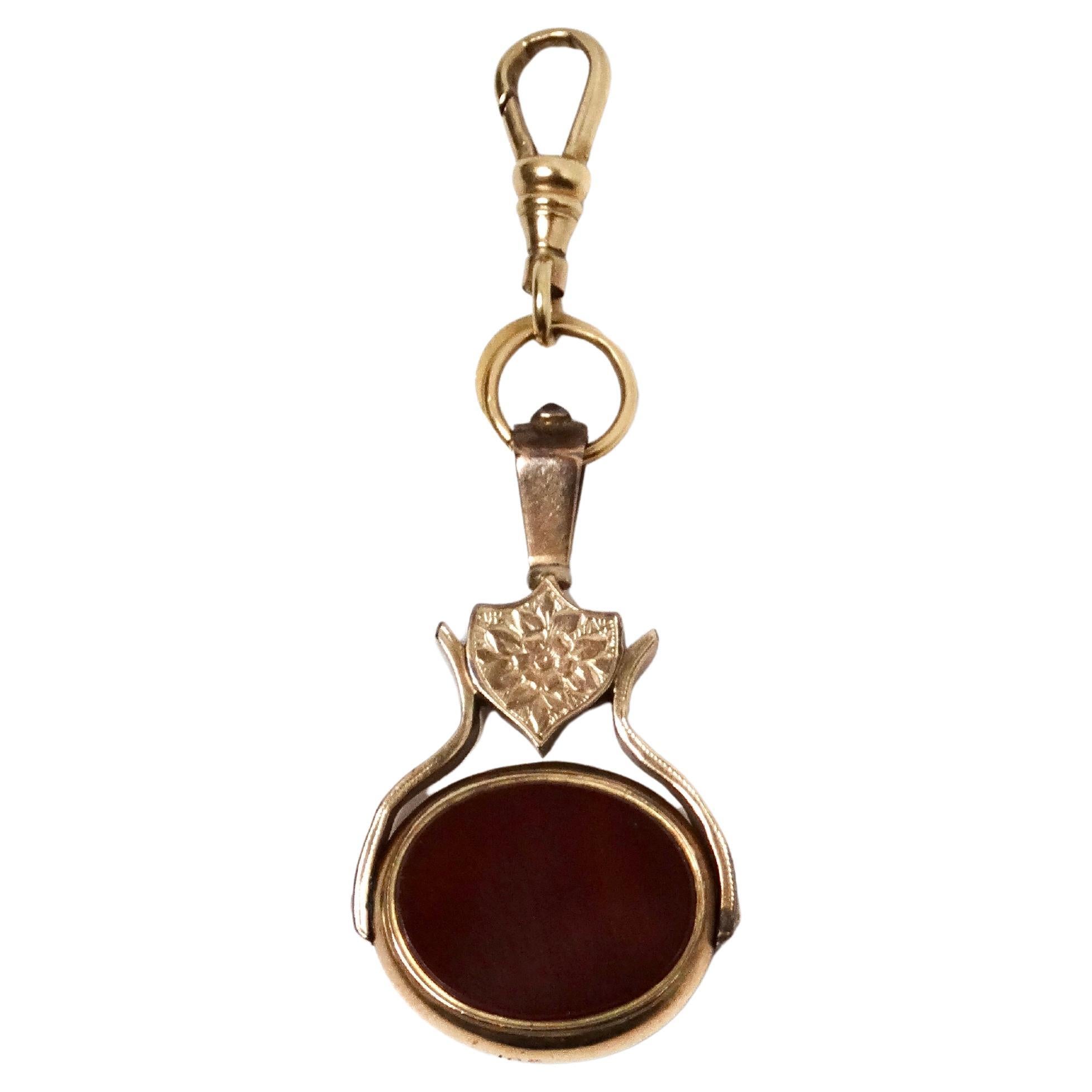 Le pendentif Victorian 10ct Gold Bloodstone & Carnelian Spinner est une pièce captivante qui allie harmonieusement le savoir-faire historique et l'élégance moderne. Fabriqué en or 10 carats, ce pendentif présente d'un côté une pierre de sang