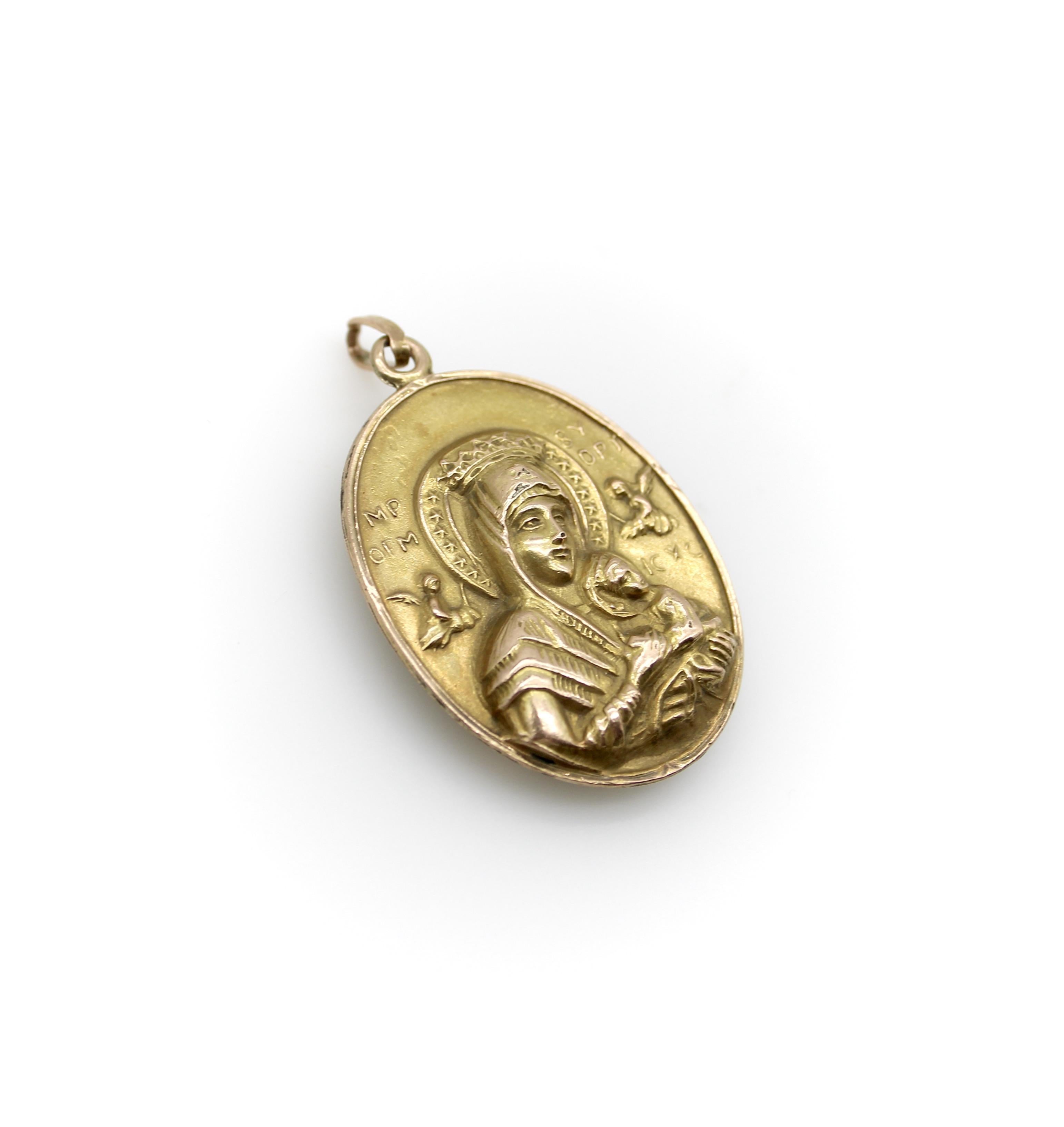 Ce pendentif victorien en or 10k est réalisé en mode repoussé et présente des variations plus anciennes de l'iconographie religieuse populaire. Le médaillon est constitué de deux pièces, chacune portant l'image martelée. Les deux parties ont ensuite