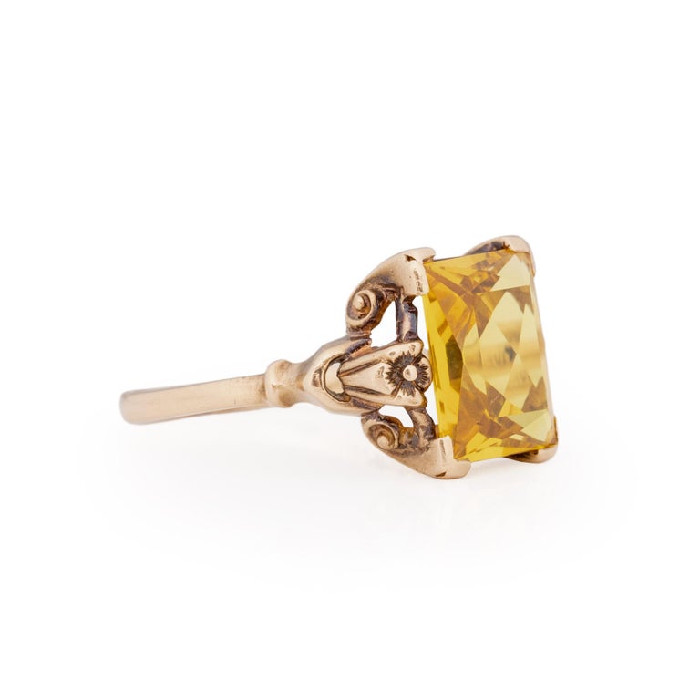 Here we have a vibrant citrine that is as yellow as the sun. This breathtaking gem sits in a 10K yellow gold four prongs setting with the rectangle sitting length wise down your finger. On either side of the gem are hand carved flowers that give the