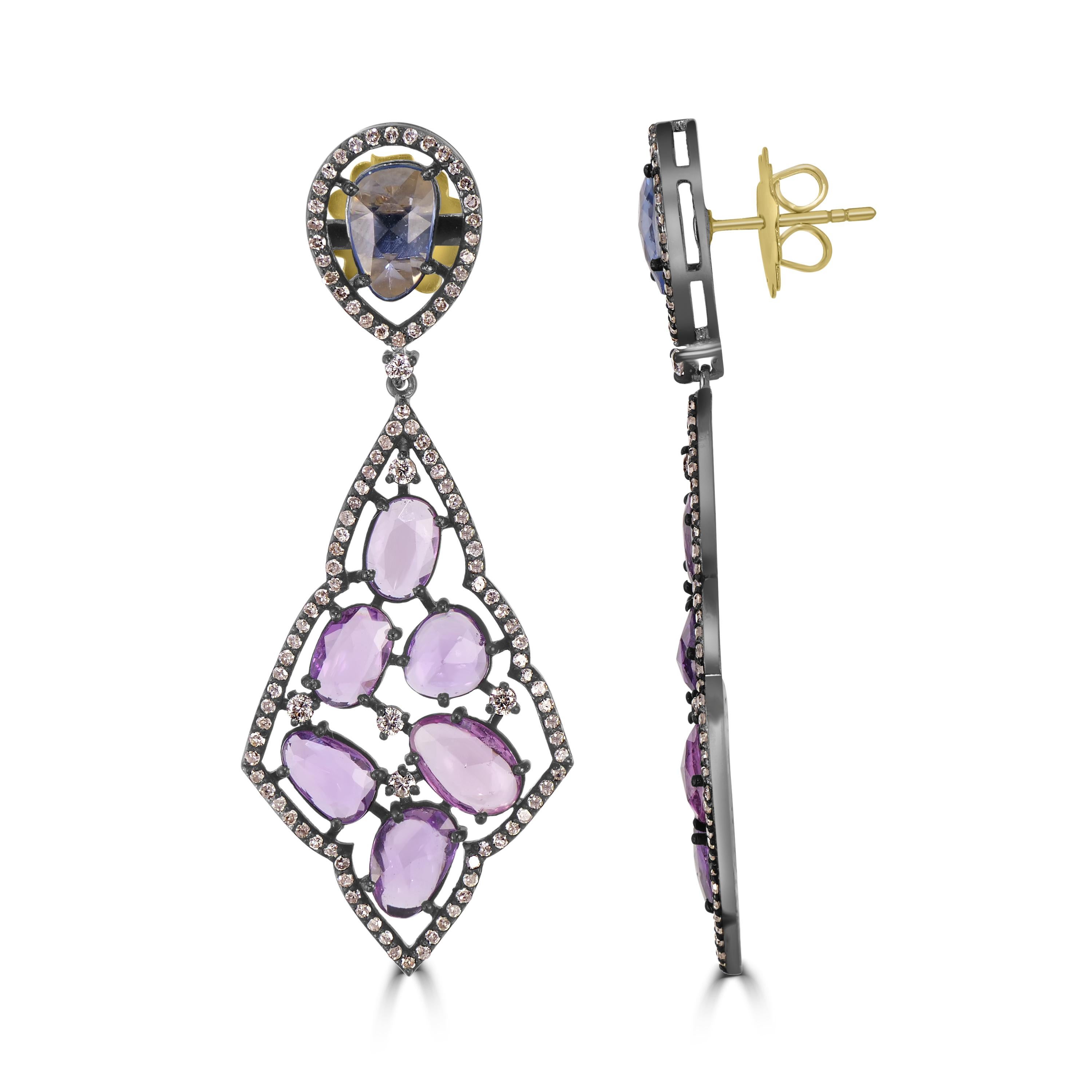 In these striking dazzling Victorian danglers, a pair of faceted blue sapphires are framed within diamonds at the top complemented with drops embellished with faceted purple sapphires prong set within a pierced frame of more diamonds. Finely crafted