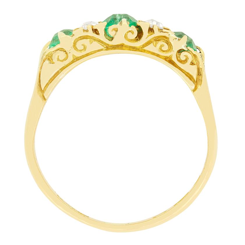 Dieser atemberaubende viktorianische Ring mit drei Steinen und geschnitztem Schaft ist mit Punzierungen aus dem Jahr 1891 versehen und zeigt ein Trio aus leuchtenden Smaragden. Der größte der drei Steine im Smaragdschliff hat ein Gewicht von 0,60