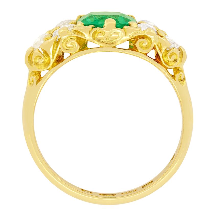 A remarkable Natural Columbian Emerald is the main feature of this stunning Victorian ring. It weighs 1.14 carat and is an old cushion cut. Set to either side are three old cut diamonds which total 1.20 carat and have been estimated as I/VS in