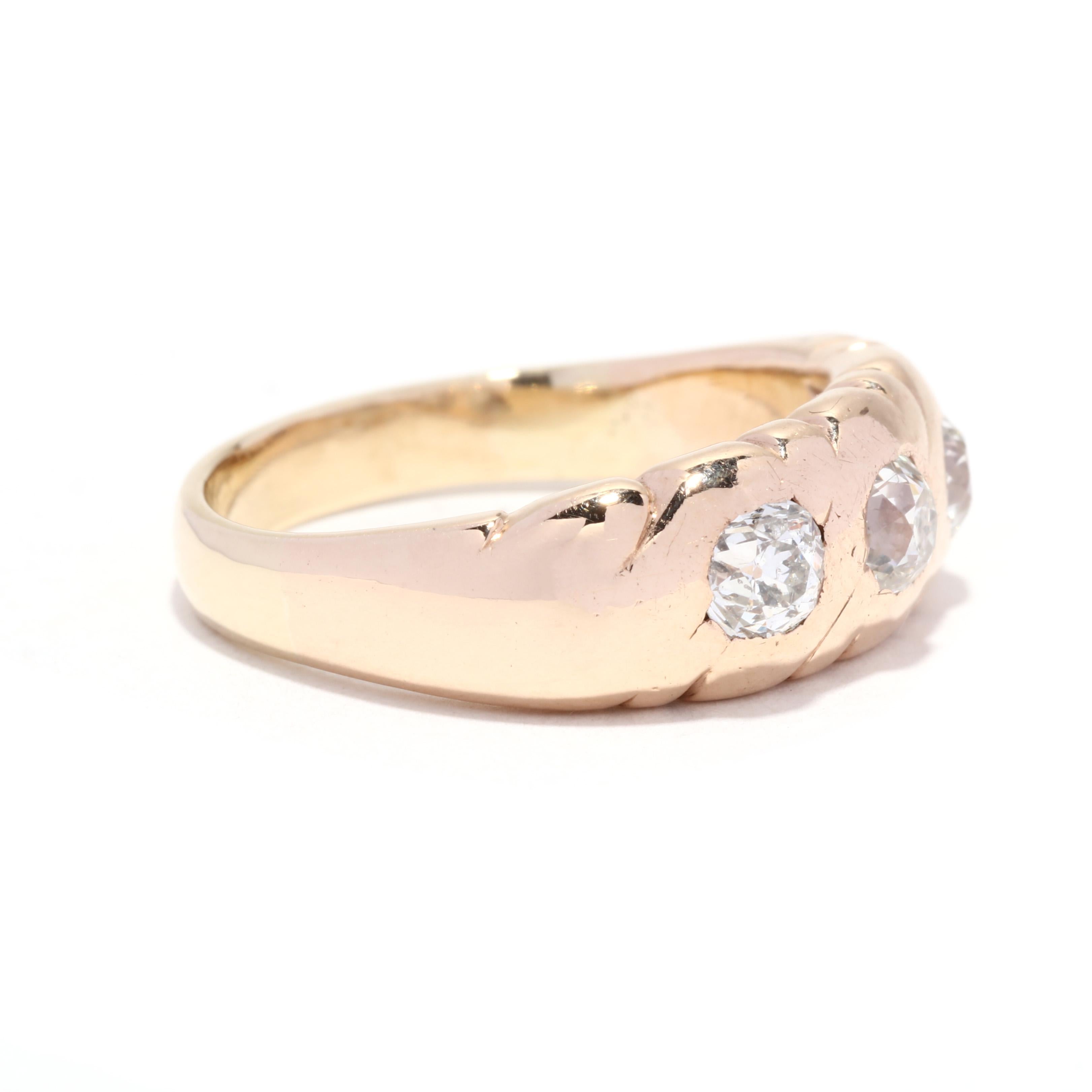 A Victorian 14 karat yellow gold old European cut diamond engagement ring. This three stone gypsy ring features three, flush set old European cut diamonds weighing approximately 1.15 total carats in a engraved edge mounting with a tapered