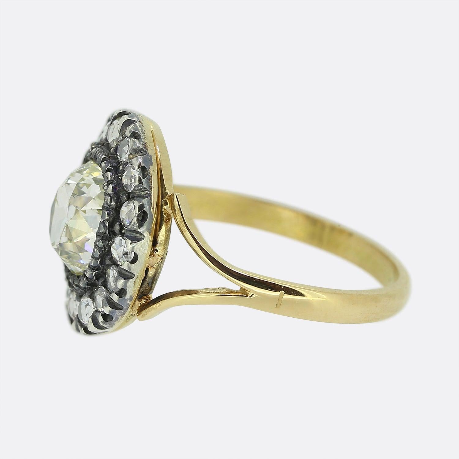 Here we have a beautifully assembled diamond cluster ring dating back to the Victorian period. A single oval shaped old mine cut diamond sits proud at the centre of the face in a silver collet setting. This chunky principle stone is then framed by a