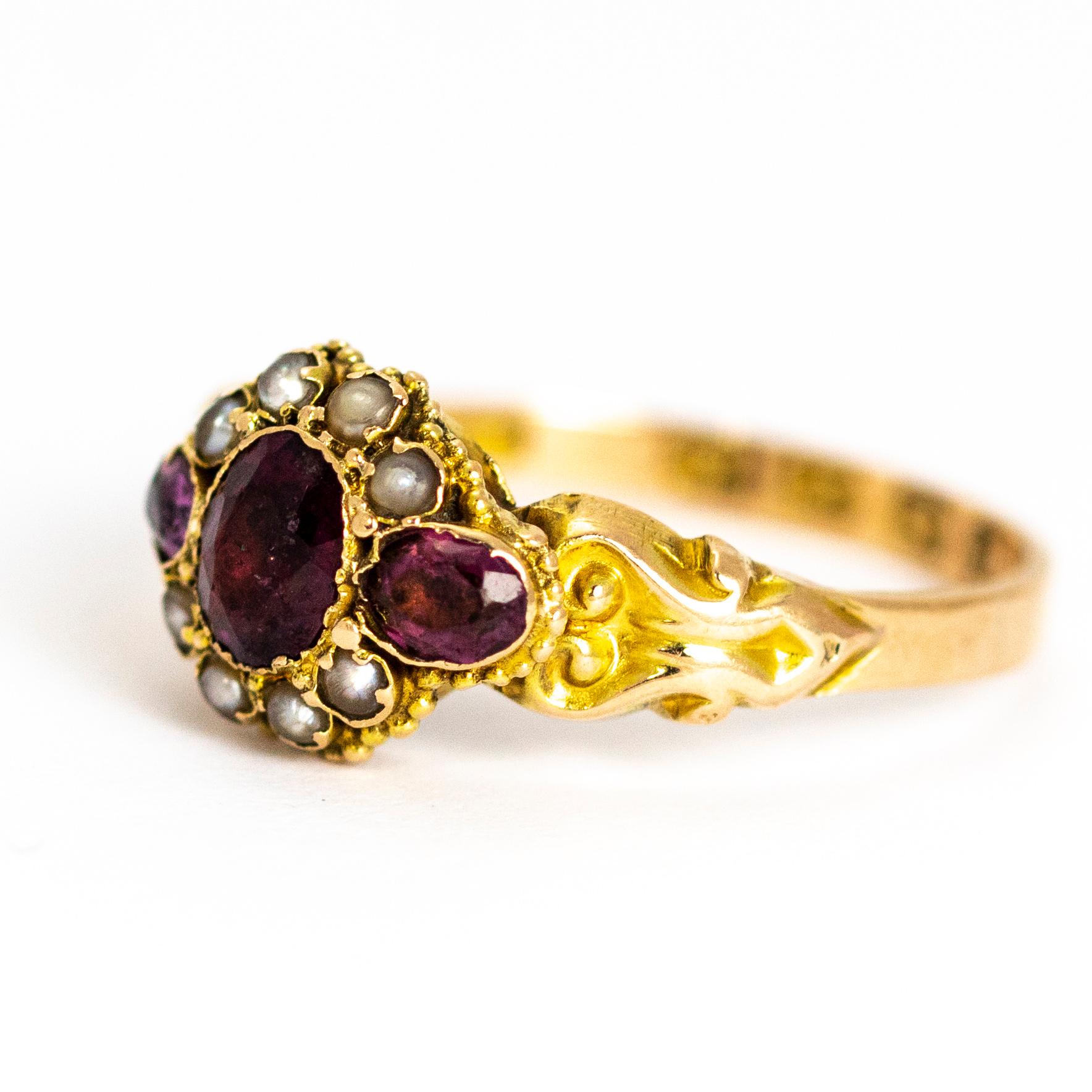 This stunning antique Victorian ring is set with a wonderful cluster of three oval amethysts and four seed pearls between beautiful ornate shoulders. The reverse of face is set with a glazed locket. Modelled in 12 karat yellow gold.

Fully