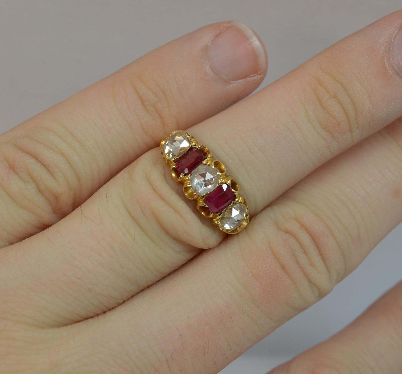 
A stunning Victorian period five stone ring. c1880.

Solid 15 carat gold shank and setting.

Designed wth three large rose cut diamonds to total 1.20 carats approx. In between are old emerald shaped red stones. 

17mm spread of stones. 7.2mm wide