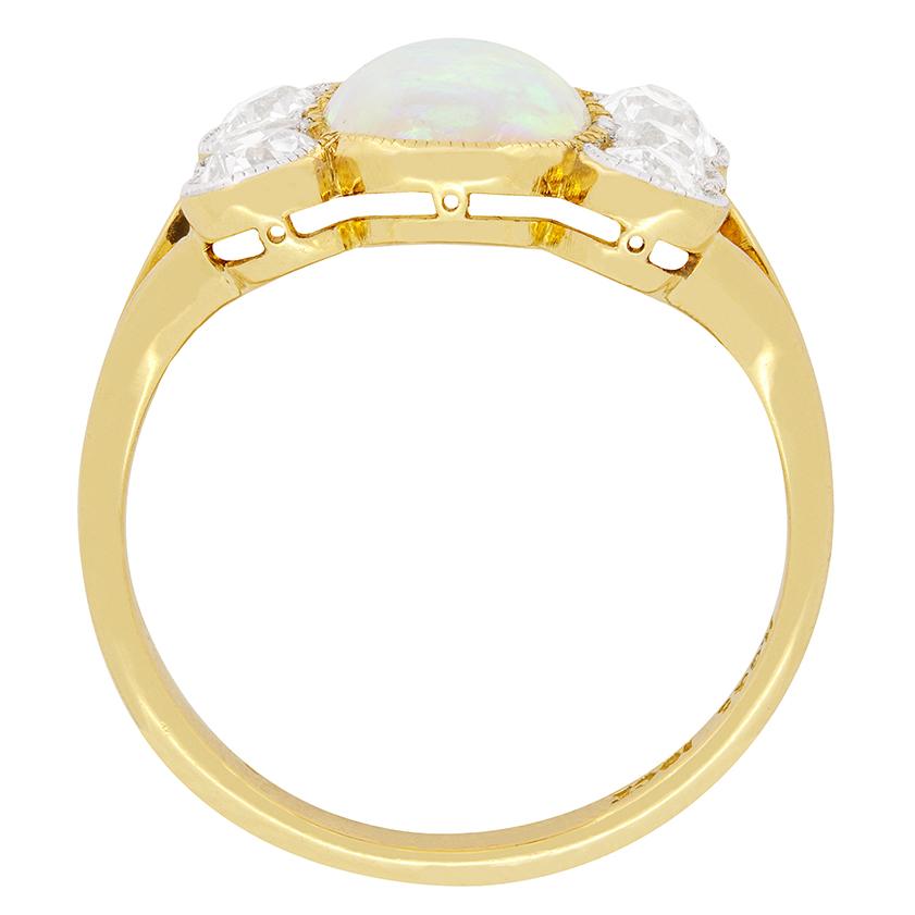 Dating back to the 1900's is this charming opal and diamond ring. The 1.20 carat oval shaped opal set in the centre shimmers in-between six old cut diamonds. The diamonds alternate in sizes with the two outer one on either side being 0.30 carats and
