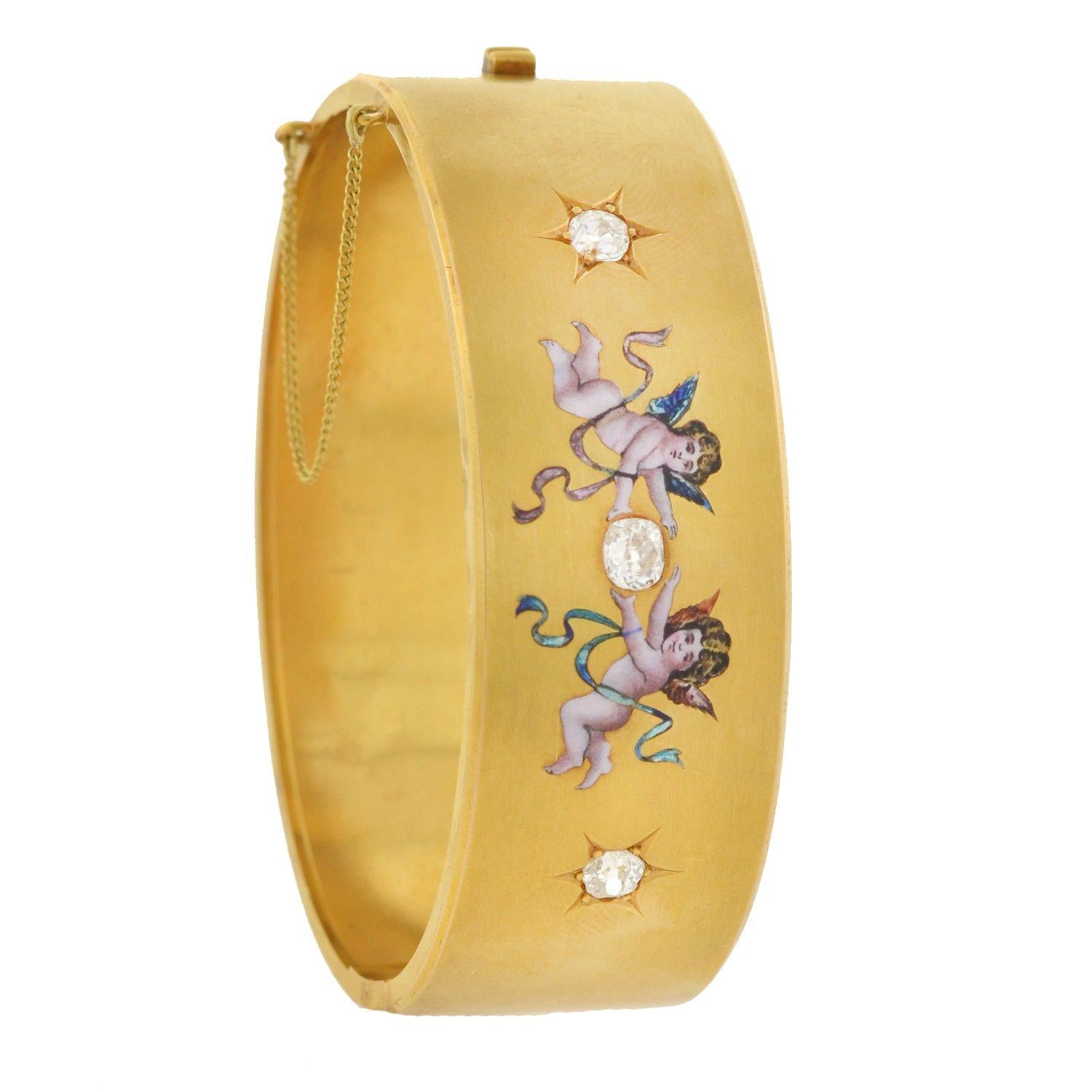 An absolutely wonderful diamond bracelet from the Victorian (ca1880) period! Crafted in 15kt yellow gold, this relatively wide bangle holds 3 sparkling diamonds at the center of a decorative and romantic enameled design. Set within the front surface