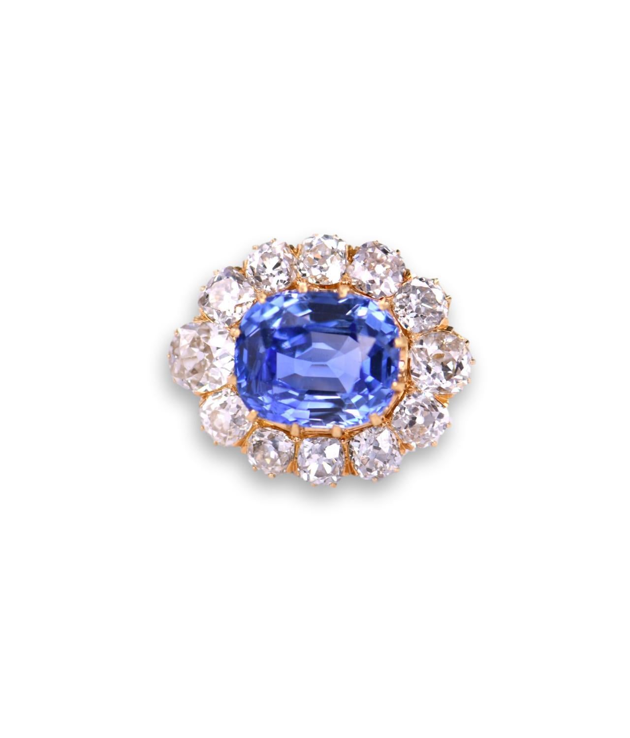 This unique 18K gold sapphire diamond brooch from the Victorian era, is centered with an impressive Ceylon No heat  GCS certified cushion cut natural blue sapphire that weighs 12ct. The sapphire is loop clean and surrounded by sparkling old mine cut