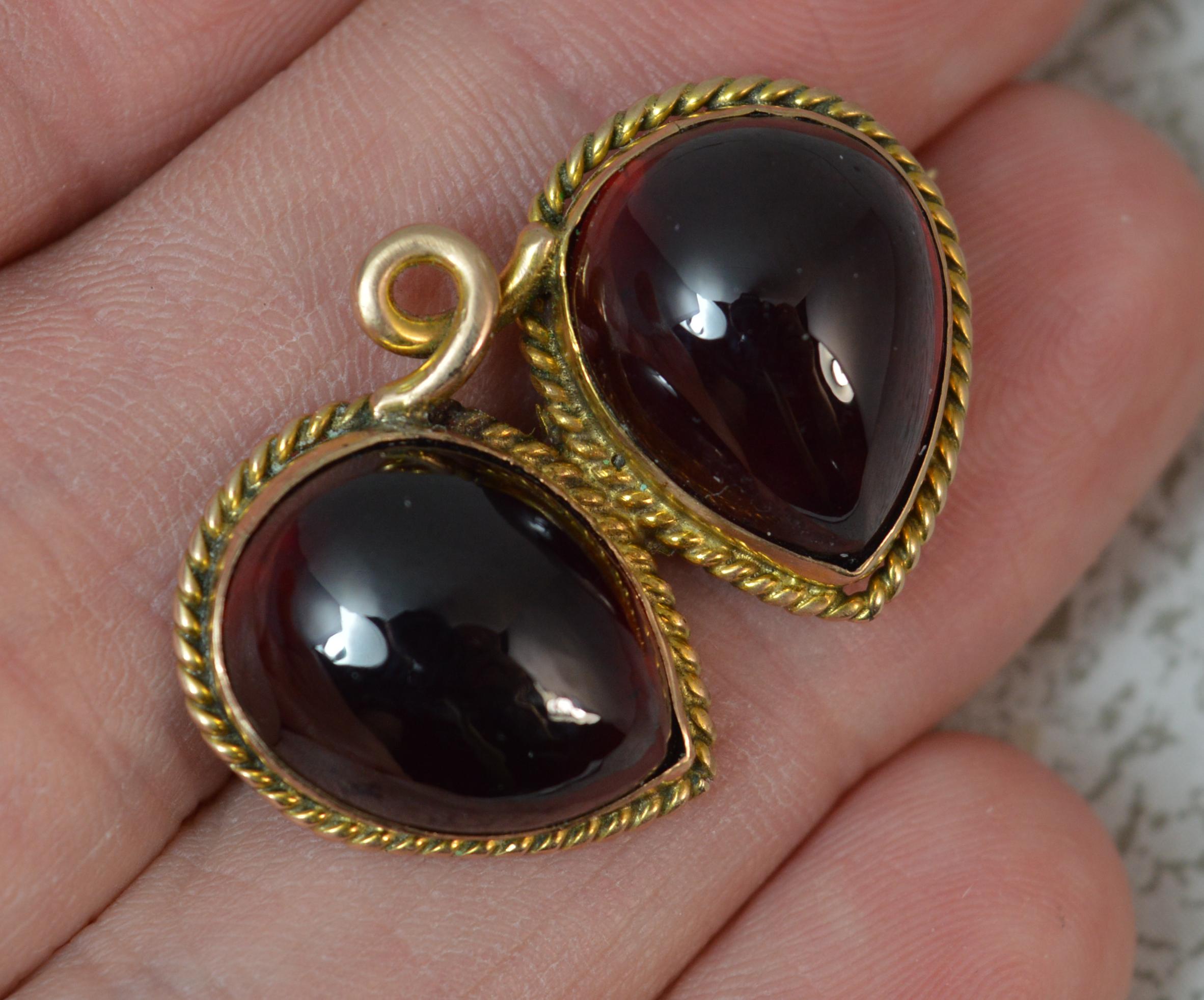 A stunning early to mid Victorian period brooch.
Solid 12 carat yellow gold example.
Comprising of two large pear shaped garnet cabochons with full gold border and surround.

CONDITION ; Very good for age. Well set stones. Working clasp. Issue free.