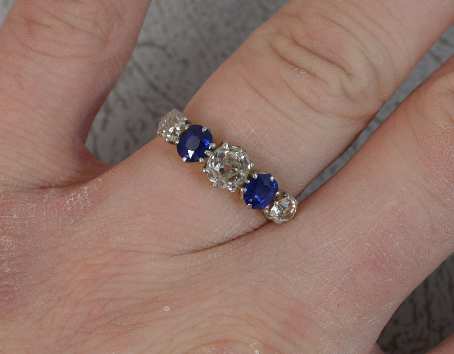 A superb late Victorian era Diamond and Sapphire ring.
SIZE ; L UK, 5 3/4 US
18 carat yellow gold shank and platinum claw head setting.
Five stone design, three natural old cut diamonds to total 1.2 carats with a blue sapphire in between. 20mm