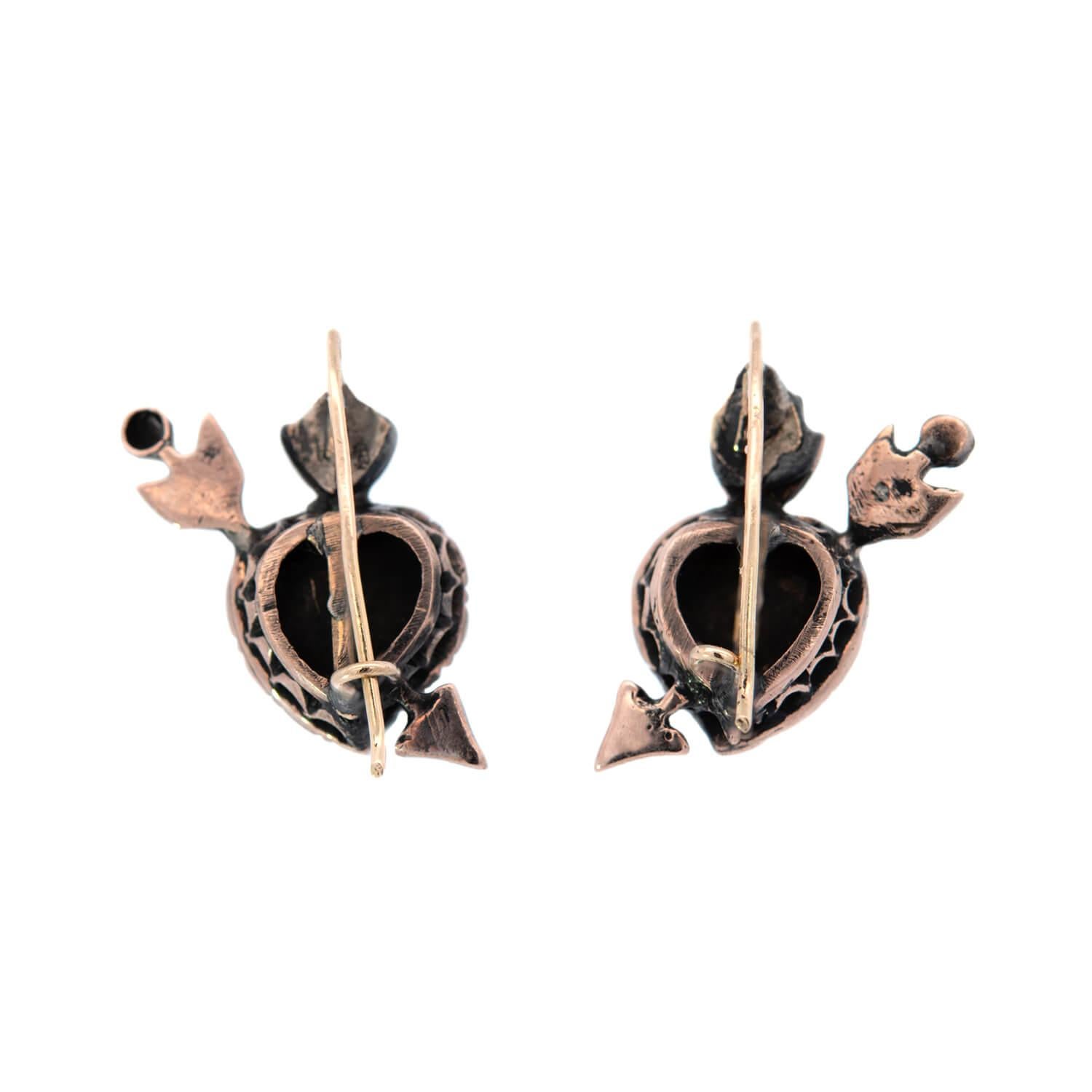 An absolutely exquisite and unusual pair of diamond heart and arrow earrings from the Victorian (ca1880) era! This striking piece, which is crafted in 12kt yellow gold depicts a diamond encrusted heart center with an arrow shooting through the