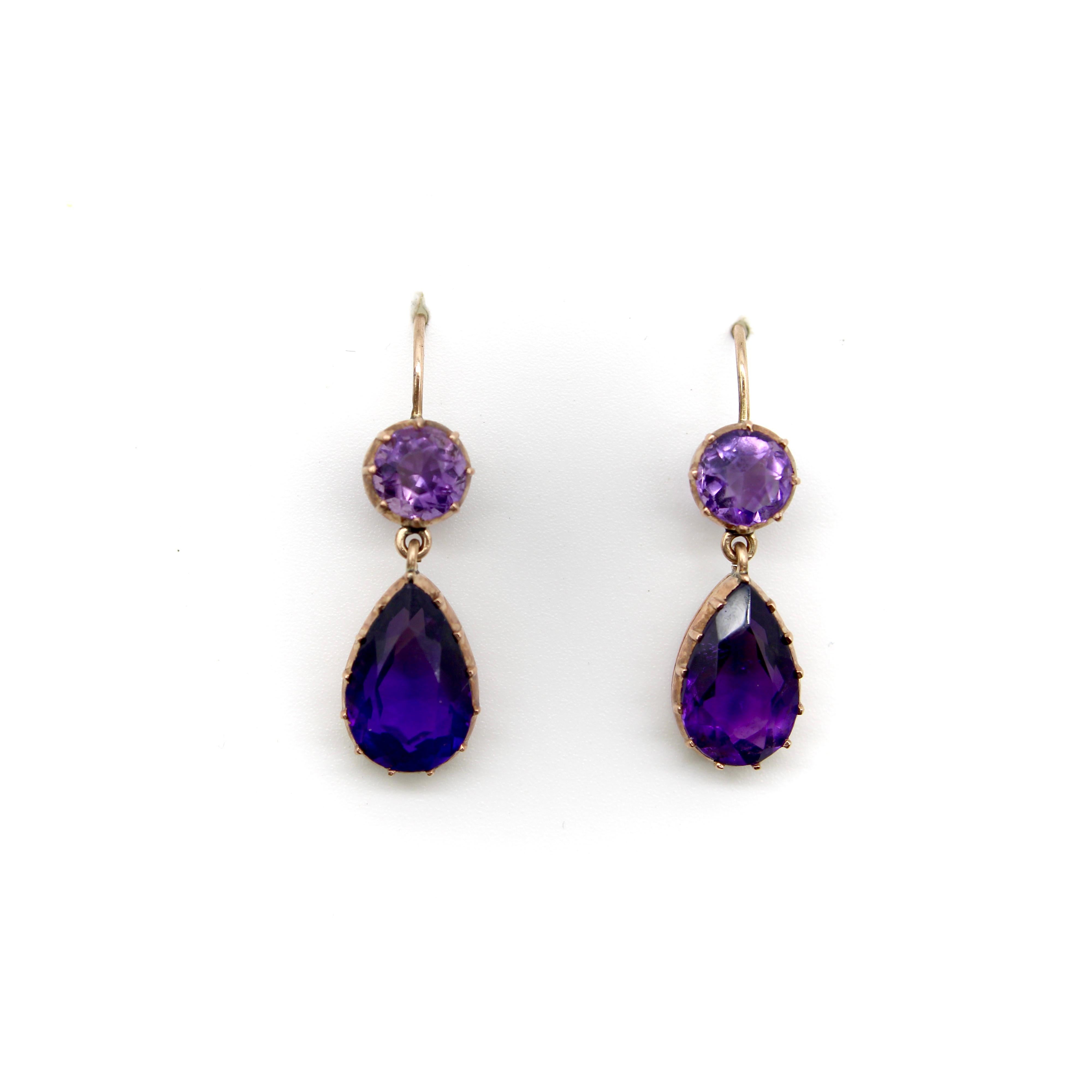 These 12k gold Victorian earrings feature beautifully saturated amethysts with pear shaped drops dangling from round gems. The stones are set in rose gold, which makes a gorgeous contrast with the saturated purple. The stones are collet set—an older