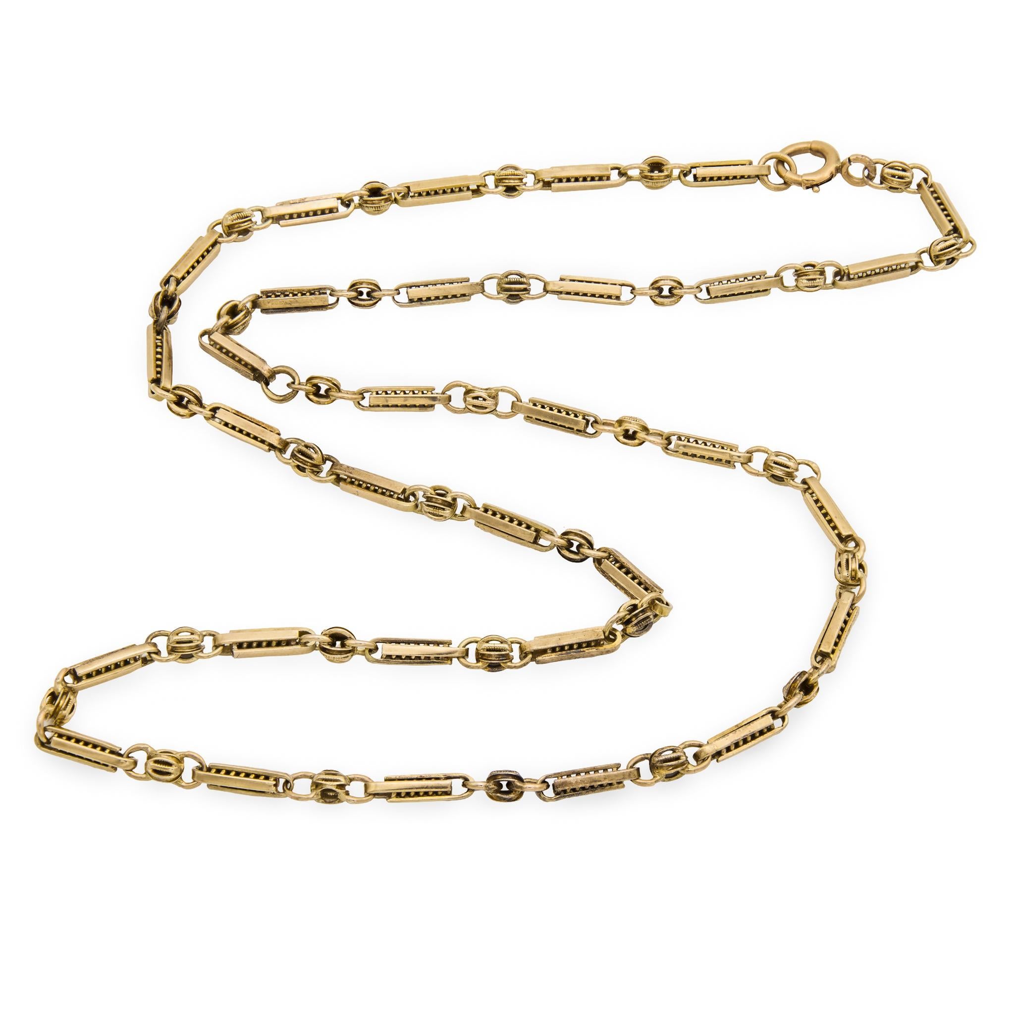 A stunning watch chain necklace from the Victorian (ca1880s) era! Crafted in 12k muted yellow gold, this necklace is comprised of alternating ellipse and bowtie-shaped links. The ellipse-shaped links feature a unique design, which incorporates