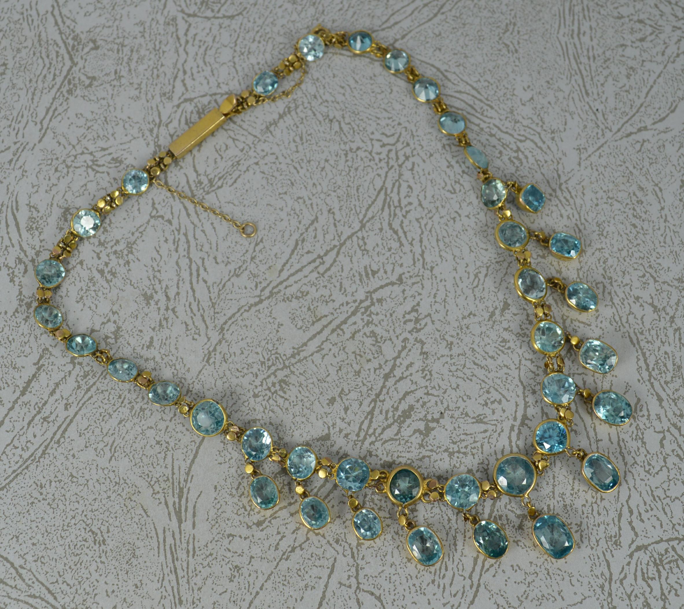 A superb late Victorian period riviere necklace chain.
Solid 12-14 carat gold example.
Designed with 15 single blue zircons with a further 12 with an oval zircon drop dangle stone below. 39 stones in total.
Finely set in gold bezel settings.
13 1/2