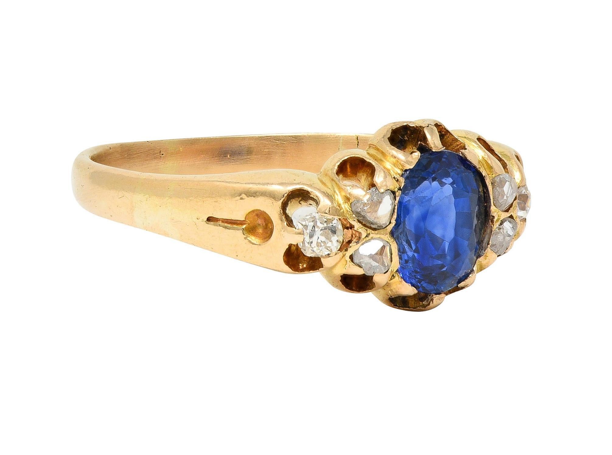 Centering a cushion-shaped sapphire weighing approximately 1.12 carats total - transparent medium blue 
Set with belcher style prongs and flanked by clustered of old mine and rose cut diamonds
Weighing approximately 0.18 carat total - quality