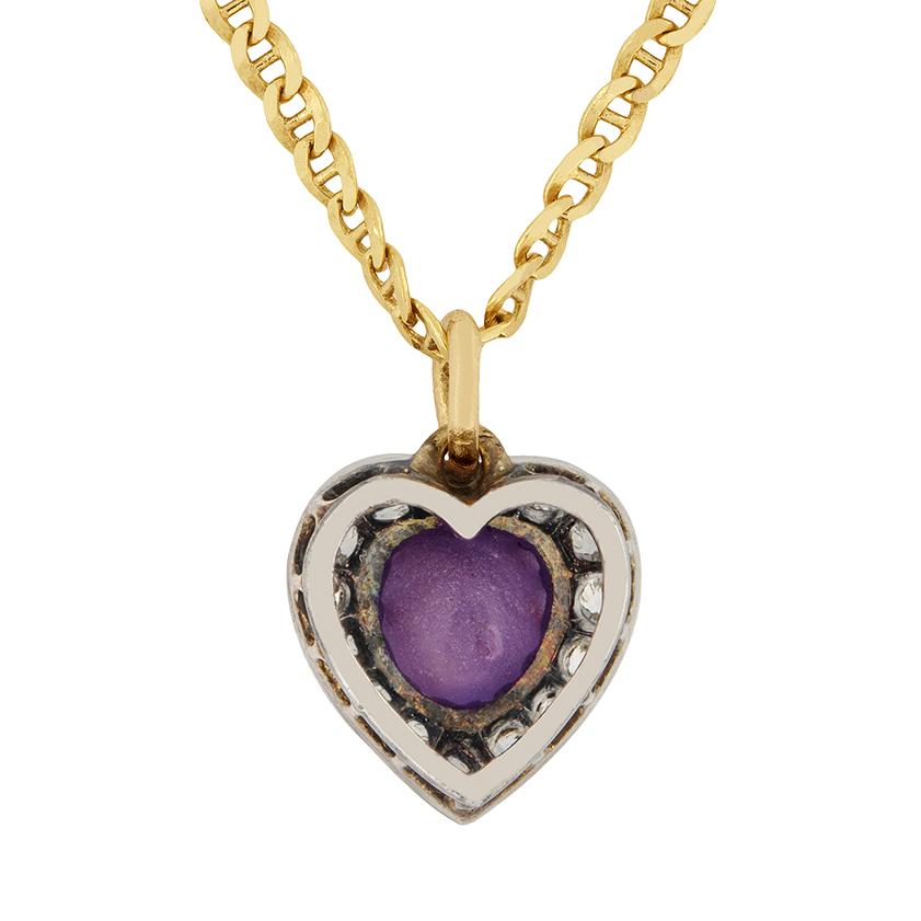A unique cabochon cut, purple star sapphire sits central to this pendant from the Victorian age. The beautiful sapphire is 1.30 carat and is surrounded by a heart shaped halo of old cut diamonds. The claw setting work is hand crafted from silver,