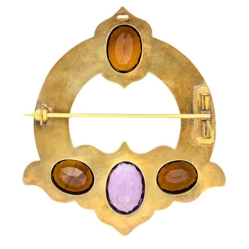 Evoking medieval craftsmanship this unique brooch was created in the Victorian era. Scottish in origin the brooch features a stunning display of gems. A 6 carat oval cut amethyst sits at its centre, with three 4.50 carat citrines set either side and