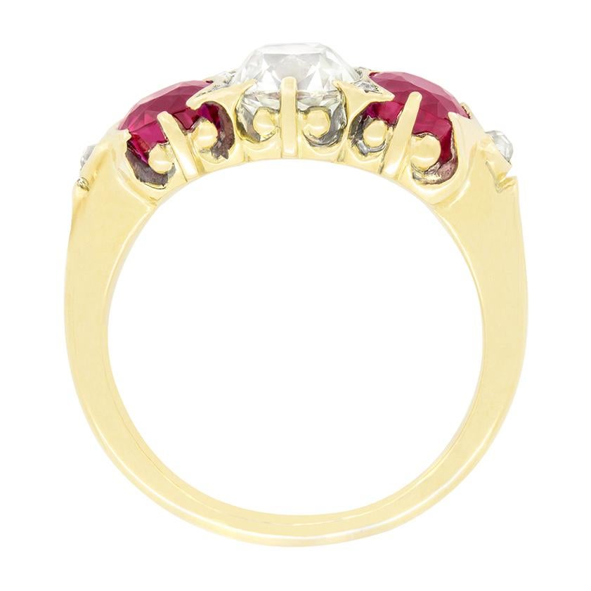 Dieser bezaubernde viktorianische Trilogie-Ring zeigt einen schönen alten Diamanten im Kissenschliff in der Mitte, flankiert von einem Paar burmesischer Rubine. Der Diamant in der Mitte hat ein Gewicht von 1,35 Karat, eine Farbe von I und eine